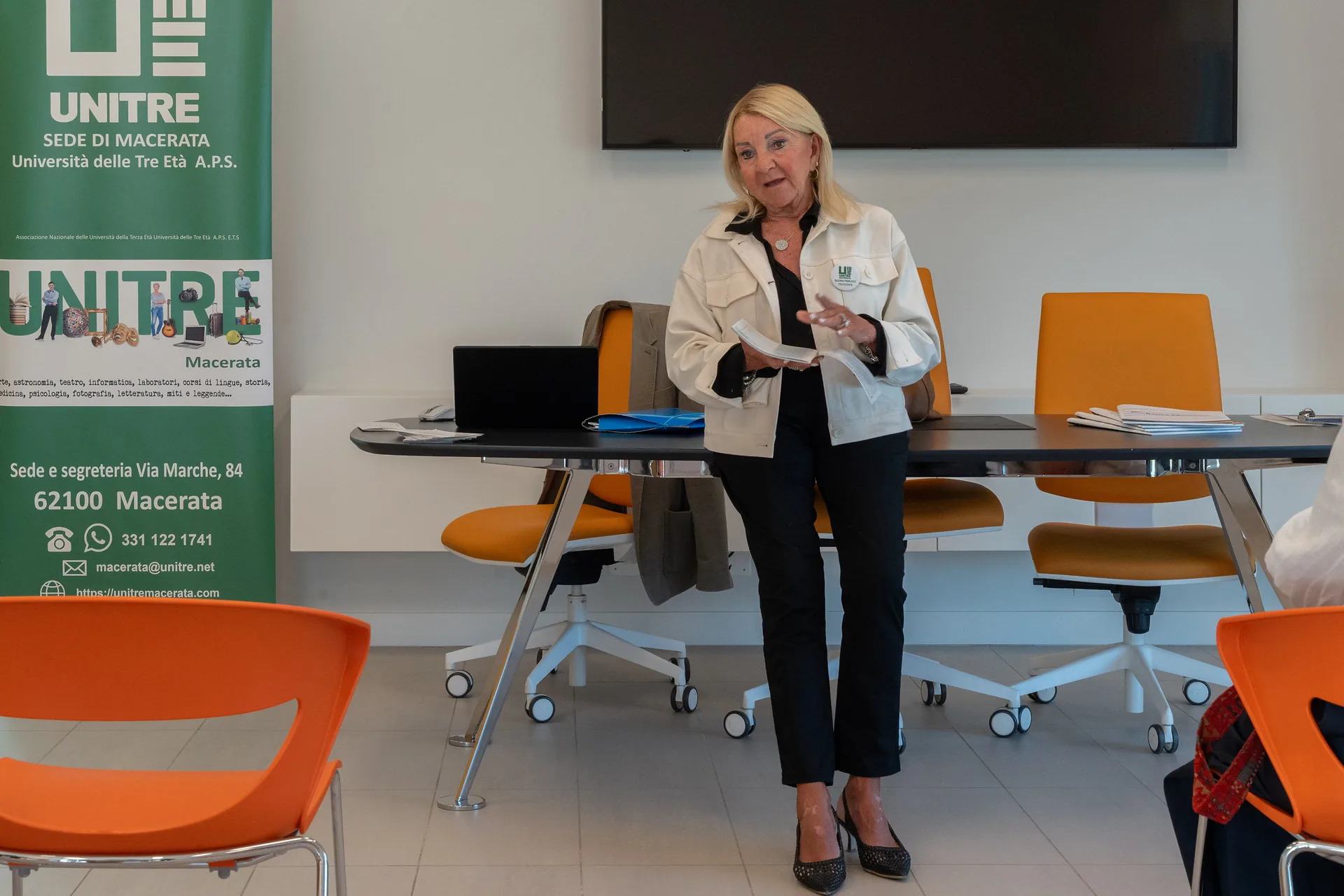 La Presidente Gloria Pierucci parla accanto al roll-up Unitre durante l'Open Day