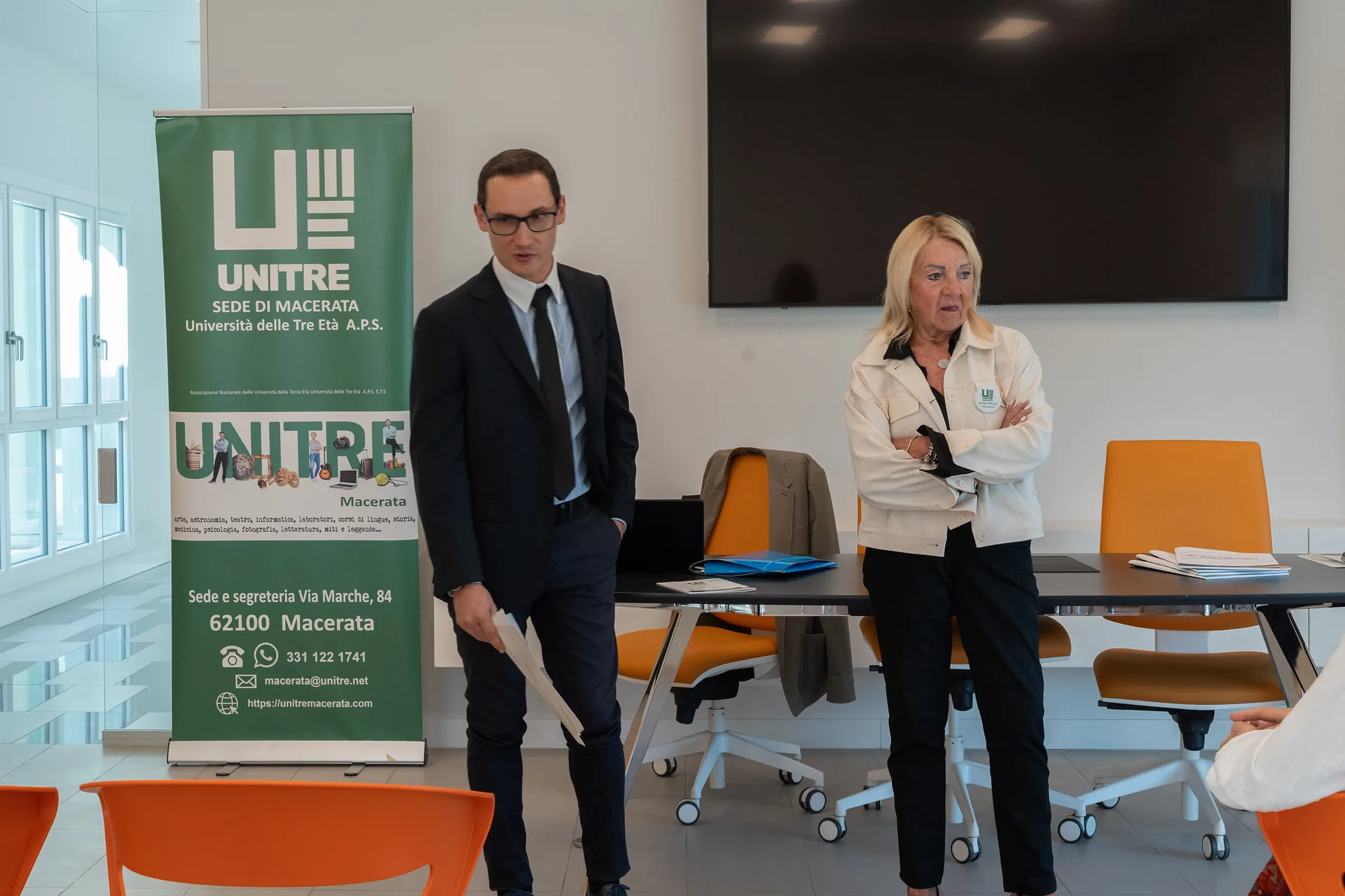 Nicola Longo di Banca Macerata presenta i corsi davanti al roll-up Unitre, accanto alla Presidente