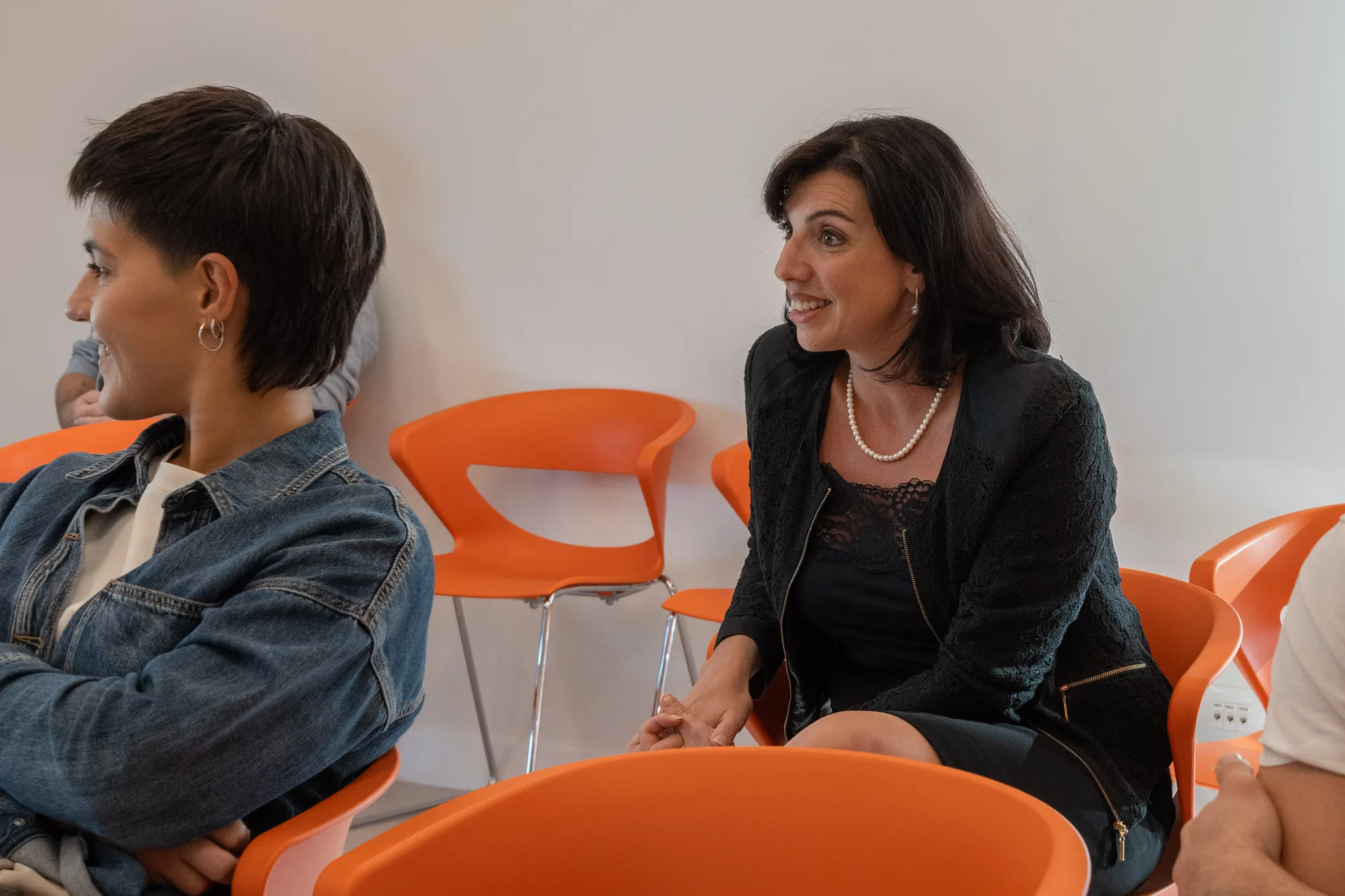Due partecipanti sorridenti seduti tra il pubblico